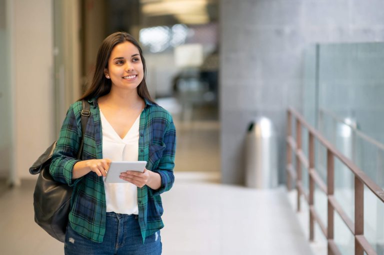 vale a pena fazer uma segunda graduação: jovem mulher em corredor de universidade