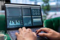 Diferença entre engenheiro, cientista e analista de dados ilustrada por tela de notebook com métricas e gráficos de Business Intelligence (BI).